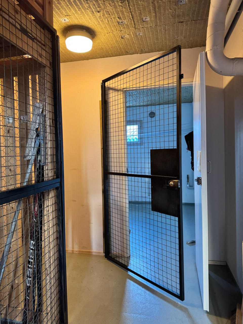 Verkkoseinäiset häkkikellarit kerrostalon kellarikäytävällä